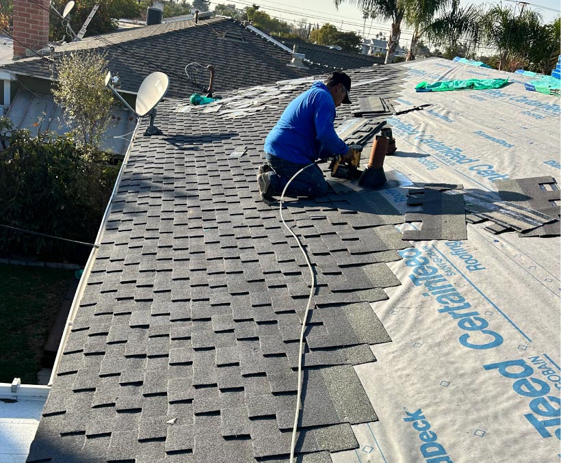 asphalt-shingle-roof Roofer installing asphalt shingles over underlayment on a residential roof