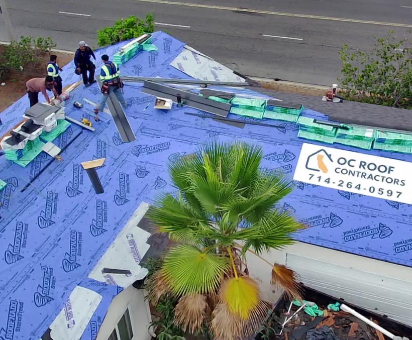 oc-roofer-contractor-work Aerial view of OC Roof Contractors crew installing underlayment on a roof in Orange County