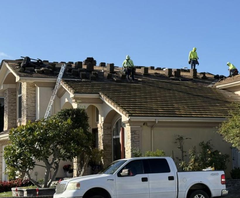 roofers-on-rooftop OC Roof Contractors crew removing old tile roofing during a roof replacement