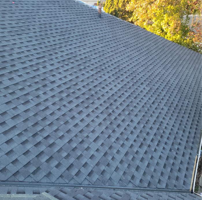 Close-up view of a newly installed dark gray asphalt shingle roof